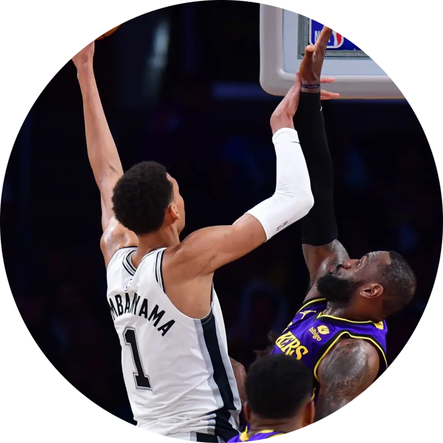 Victor Wembanyama attempting a layup while guarded by LeBron James  