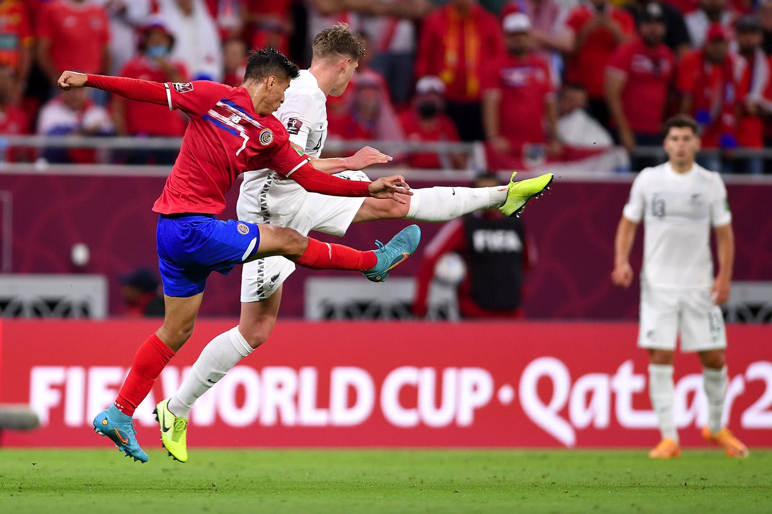 Two opposing players kick at ball during World Cup match