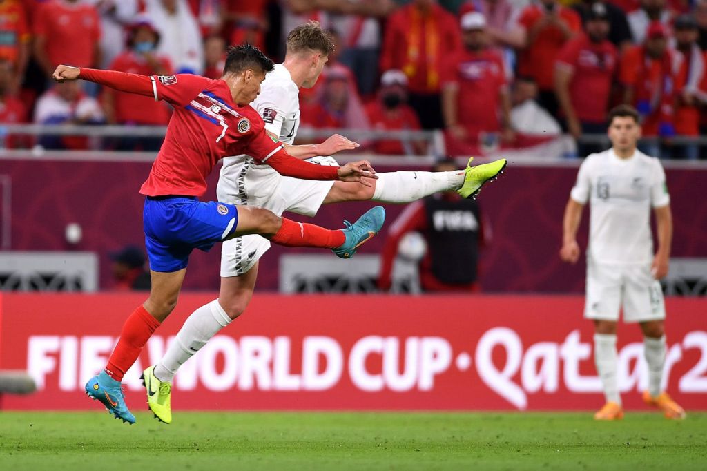 Two opposing players kick at ball during World Cup match