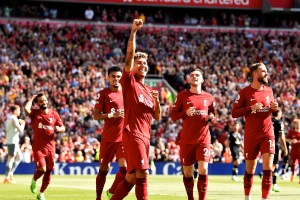Liverpool striker Roberto Firmino celebrates in front of fans after scoring a goal