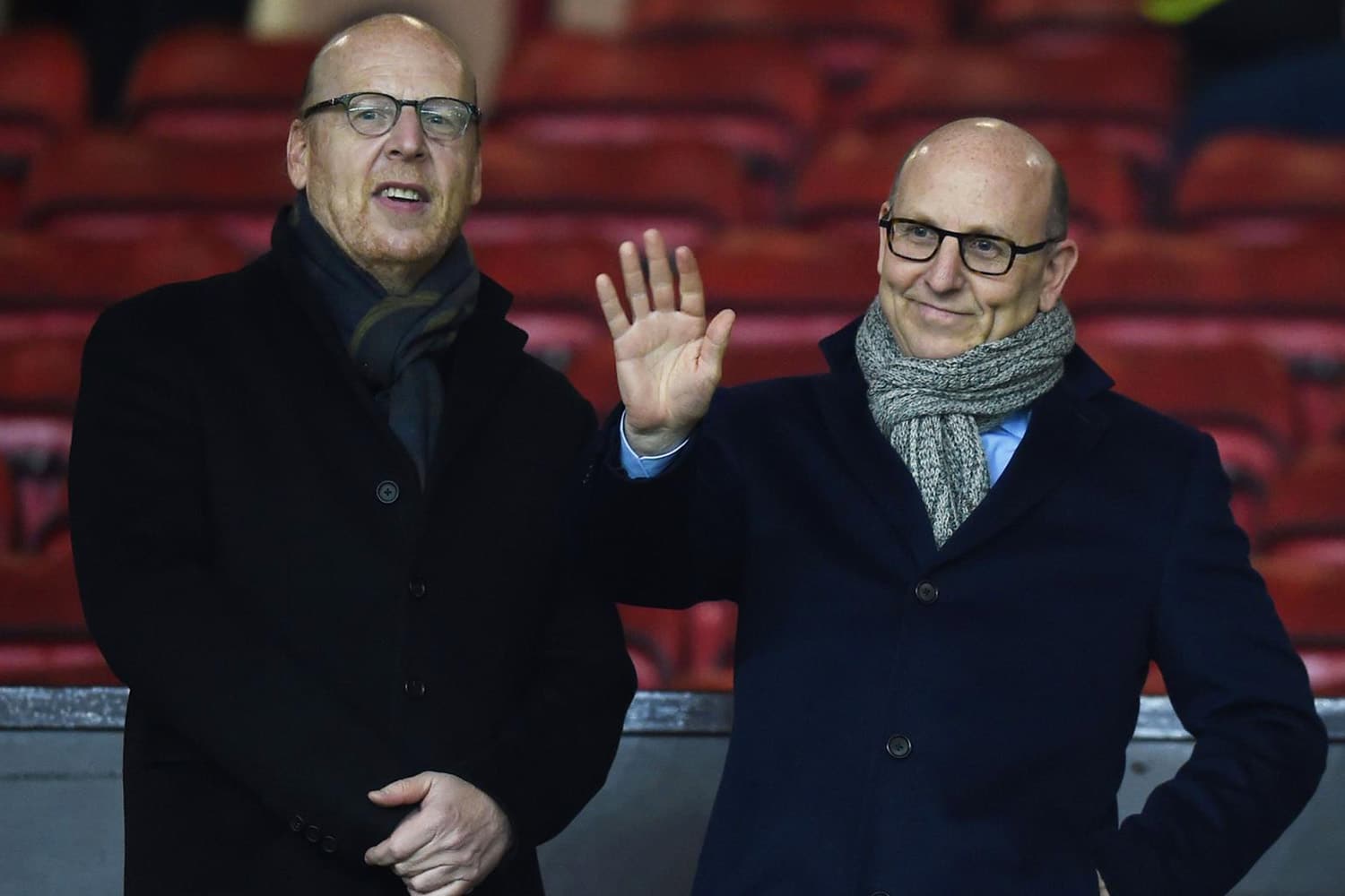 Manchester United owners Joel and Avram Glazer wave to cameras in stands of Old Trafford