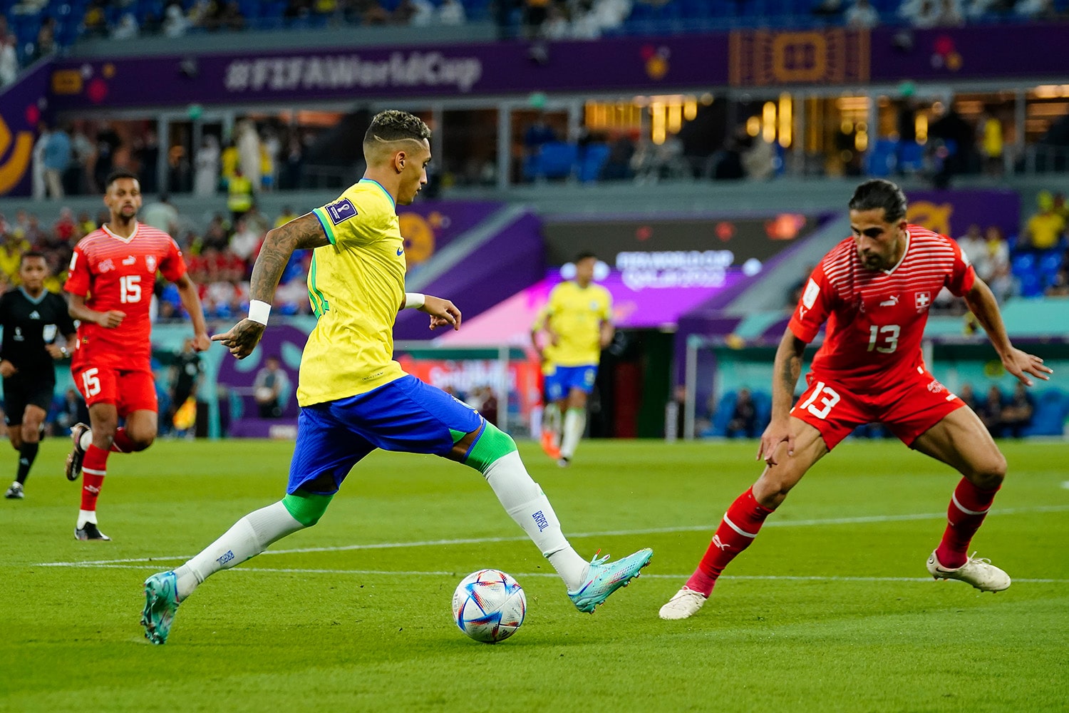 Brazilian attacker Raphinha dribbles at Swiss defender during World Cup match up