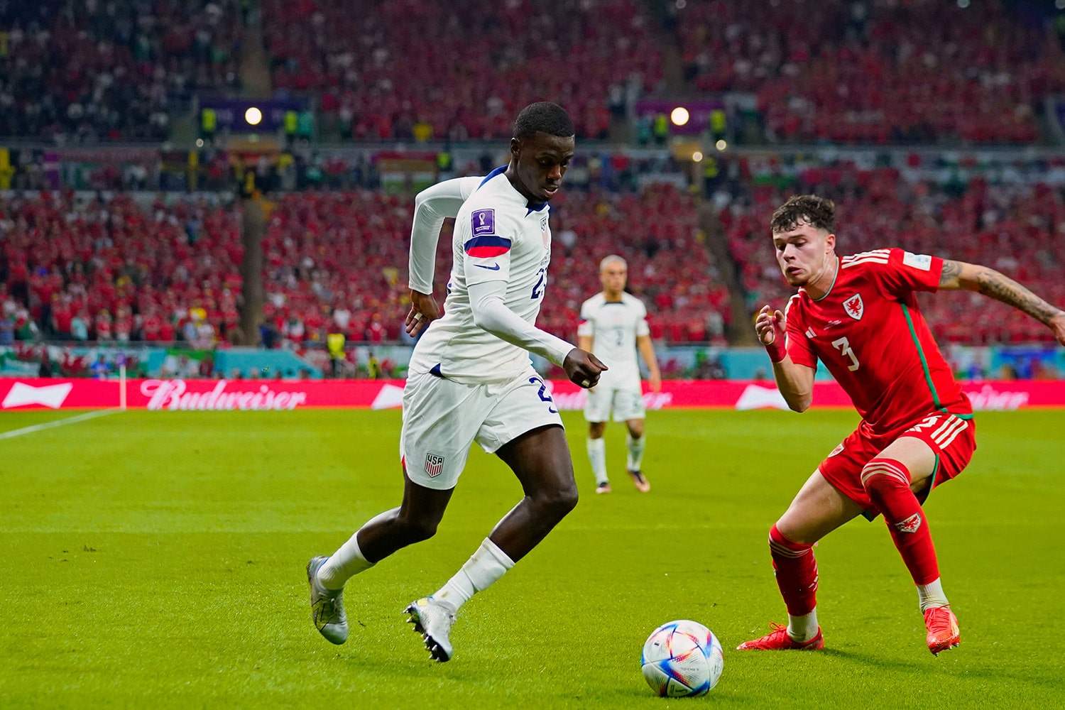 USMNT striker Tim Weah dribbles past Welsh defender in World Cup match