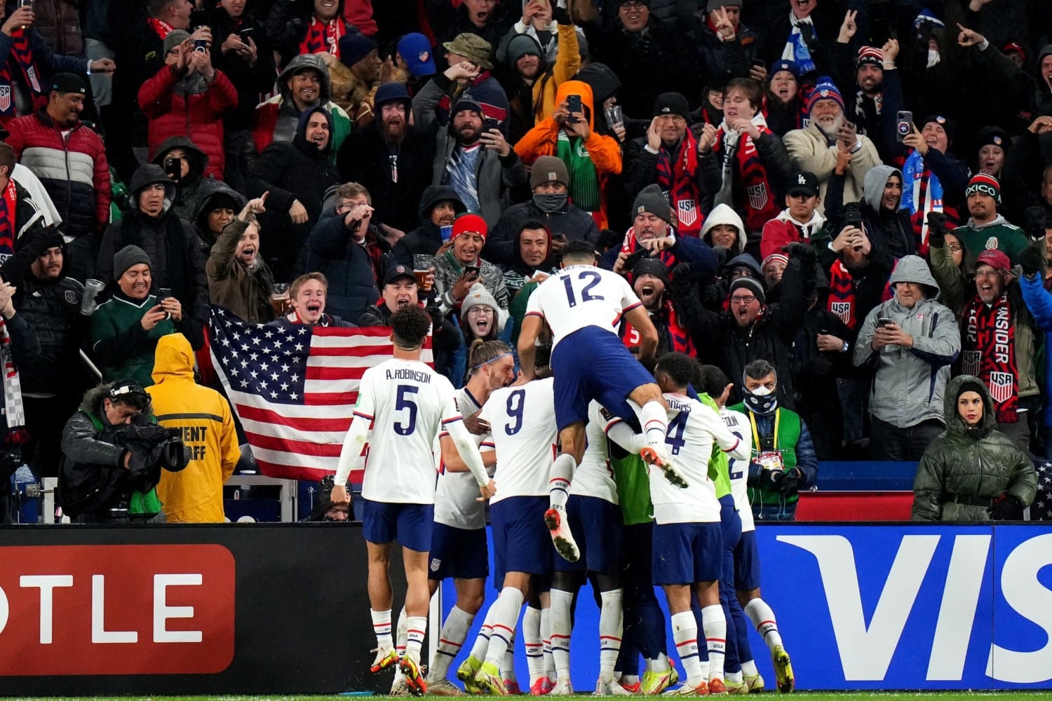 USMNT players celebrate in front of fans after scoring goal