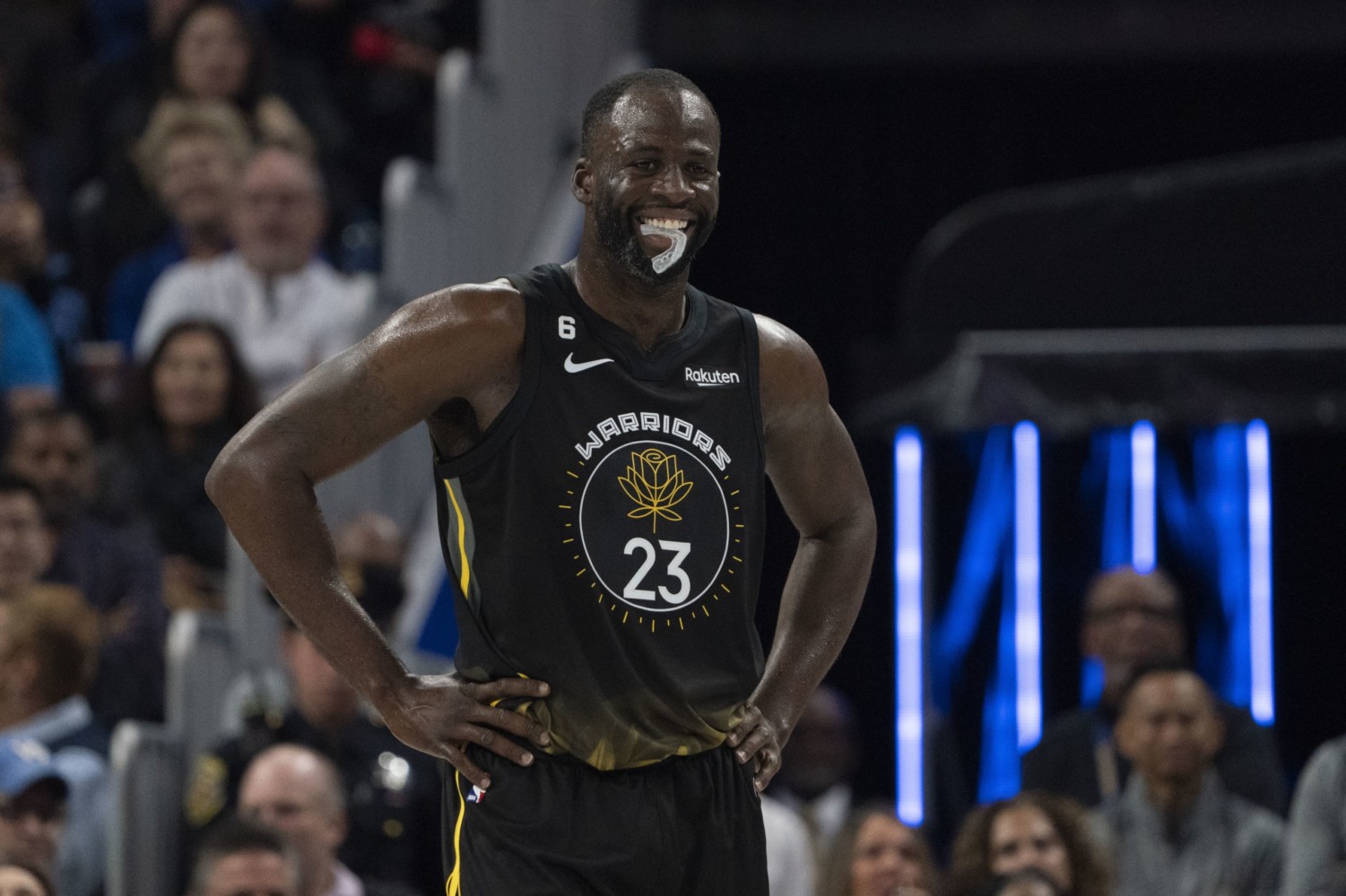 Warriors player Draymond Green chewing mouthguard and standing with hands on hip during NBA game
