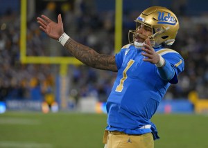 UCLA quarterback Dorian Thompson-Robinson raises arms while looking into crowd during college football game