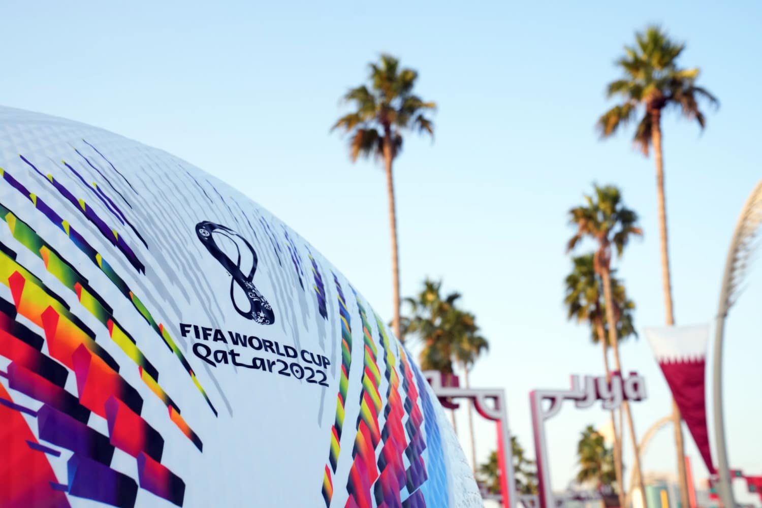 Qatar World Cup official match ball in front of palm trees 