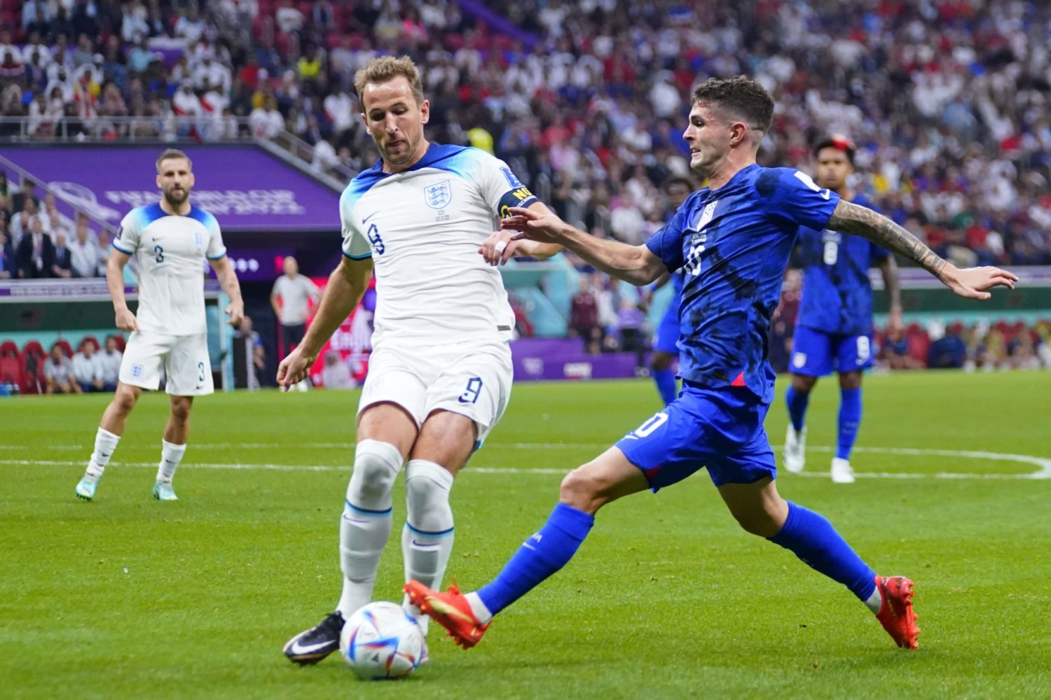 Christian Pulisic and Harry Kane compete for loose ball in match-up between United States and England in the World Cup