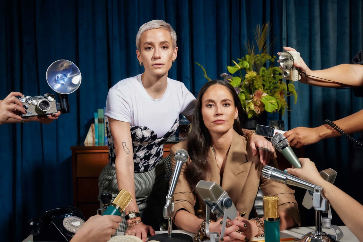 American sports stars Megan Rapinoe and Sue Bird pose for photos in front of microphone