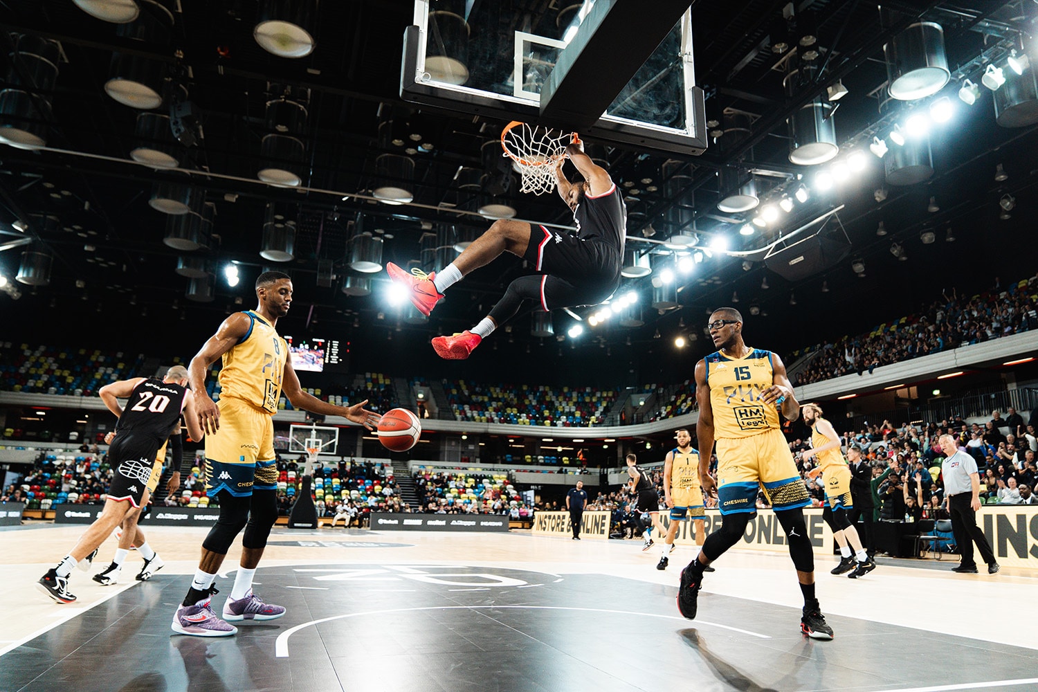 London Lions player hangs on rim after big dunking during a game