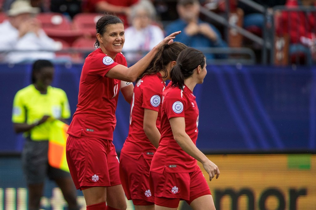 Canadian women's national team players celebrate after scoring goal