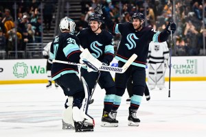 Seattle Kraken skaters celebrate with goaltender Martin Jones