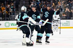 Seattle Kraken skaters celebrate with goaltender Martin Jones
