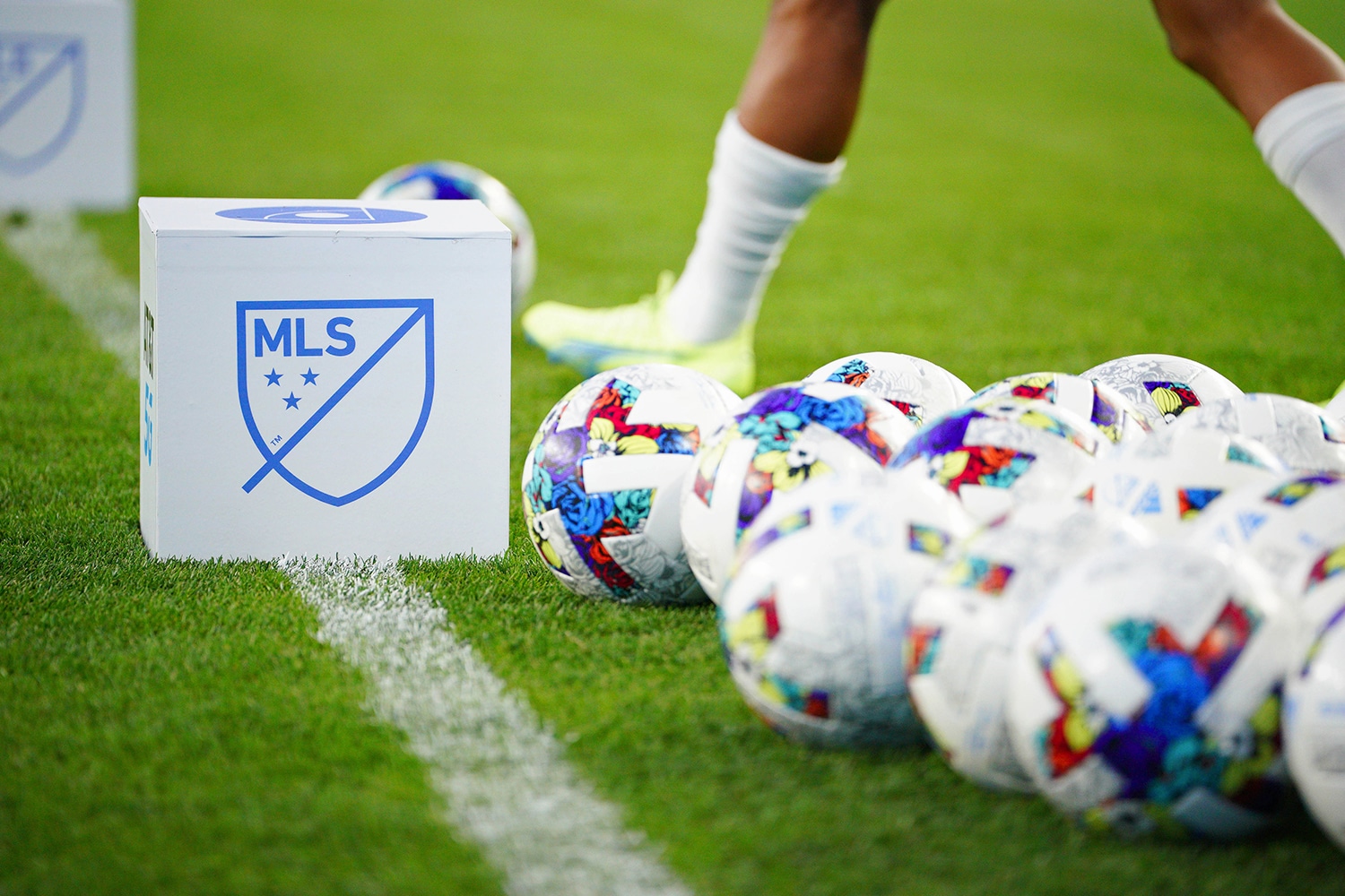 Multiple soccer balls on sideline of MLS game
