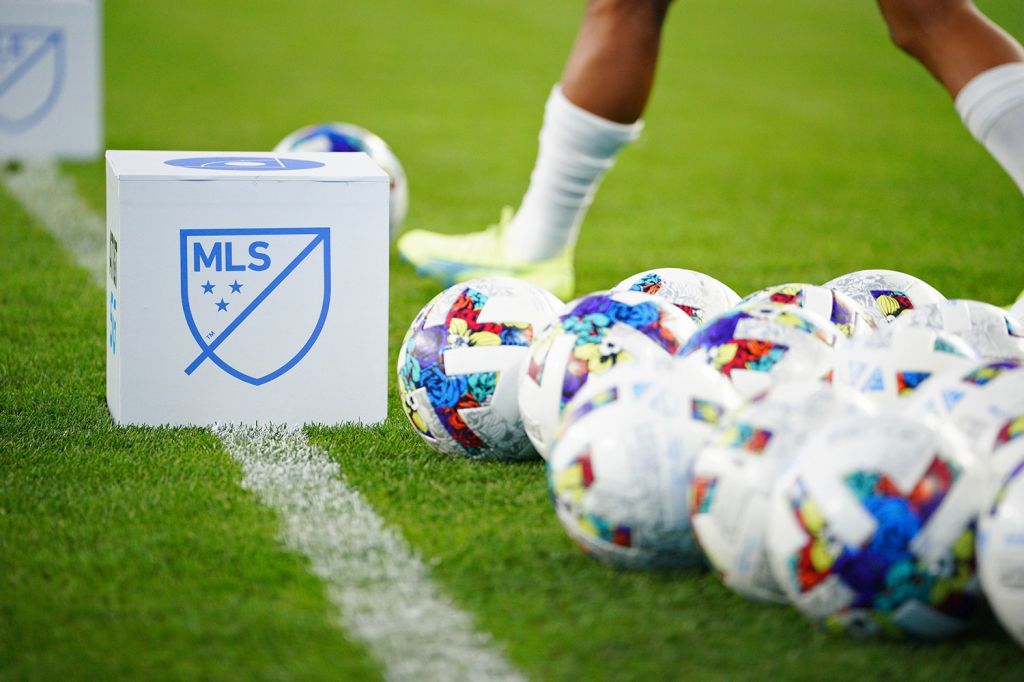 Multiple soccer balls on sideline of MLS game