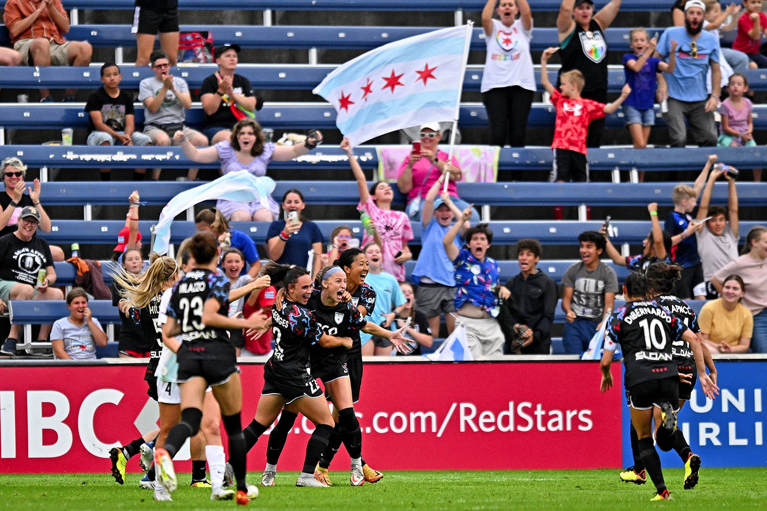 NWSL Chicago Red Stars players celebrate in front of fans after scoring goal