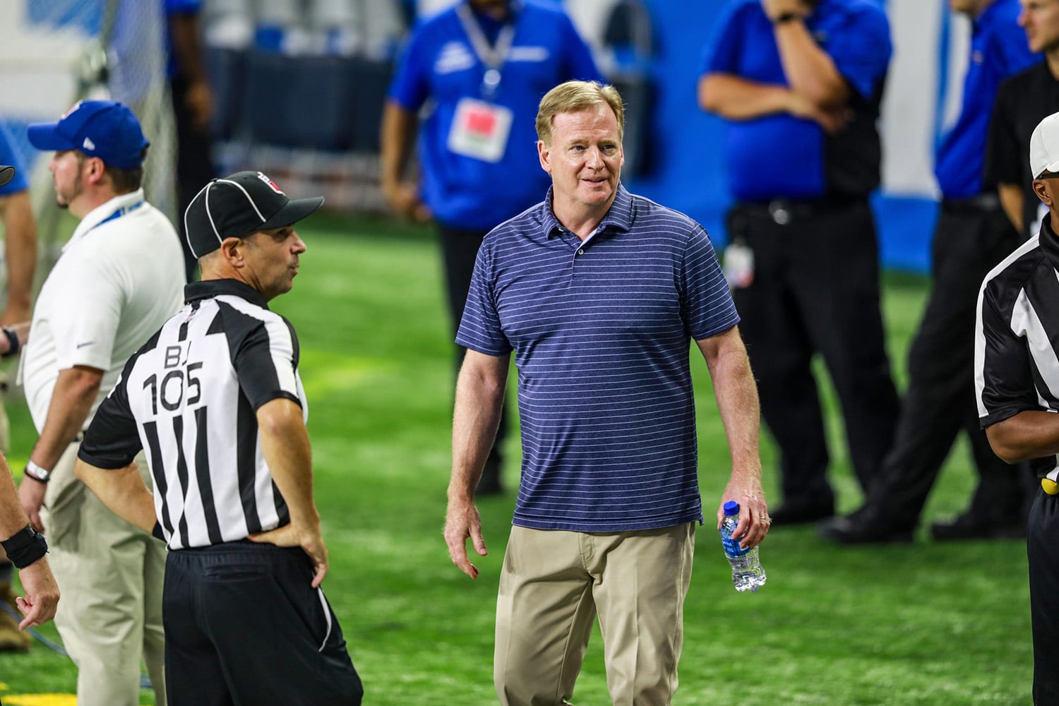 NFL Commissioner Roger Goodell standing next to official during a game