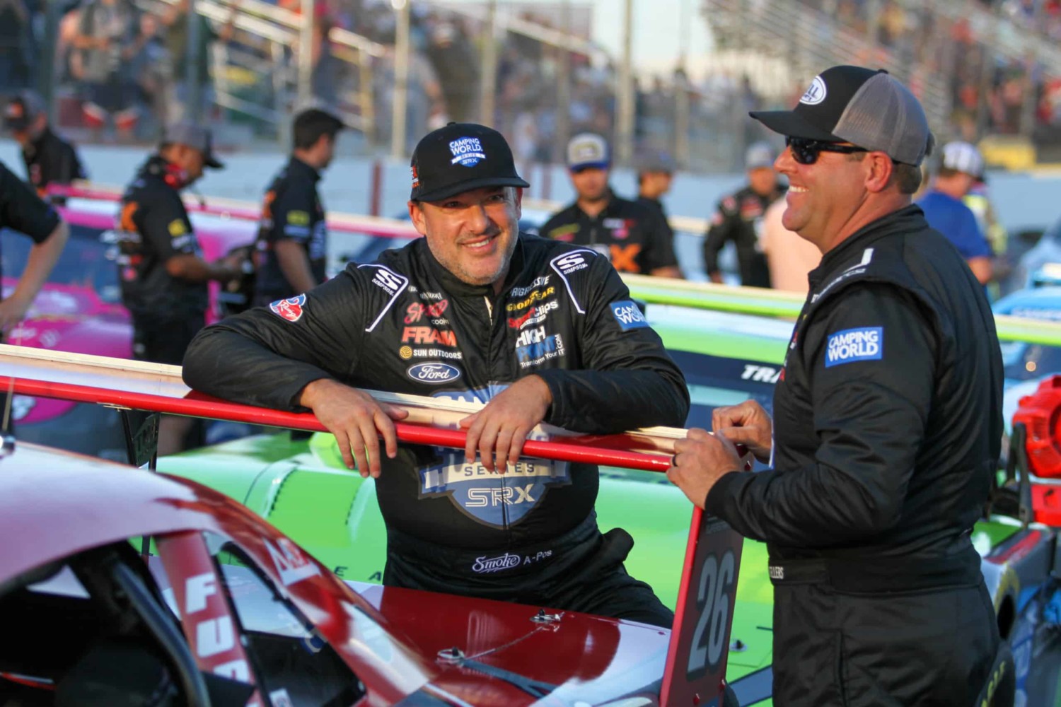 Tony Stewart leans against spoiler of car