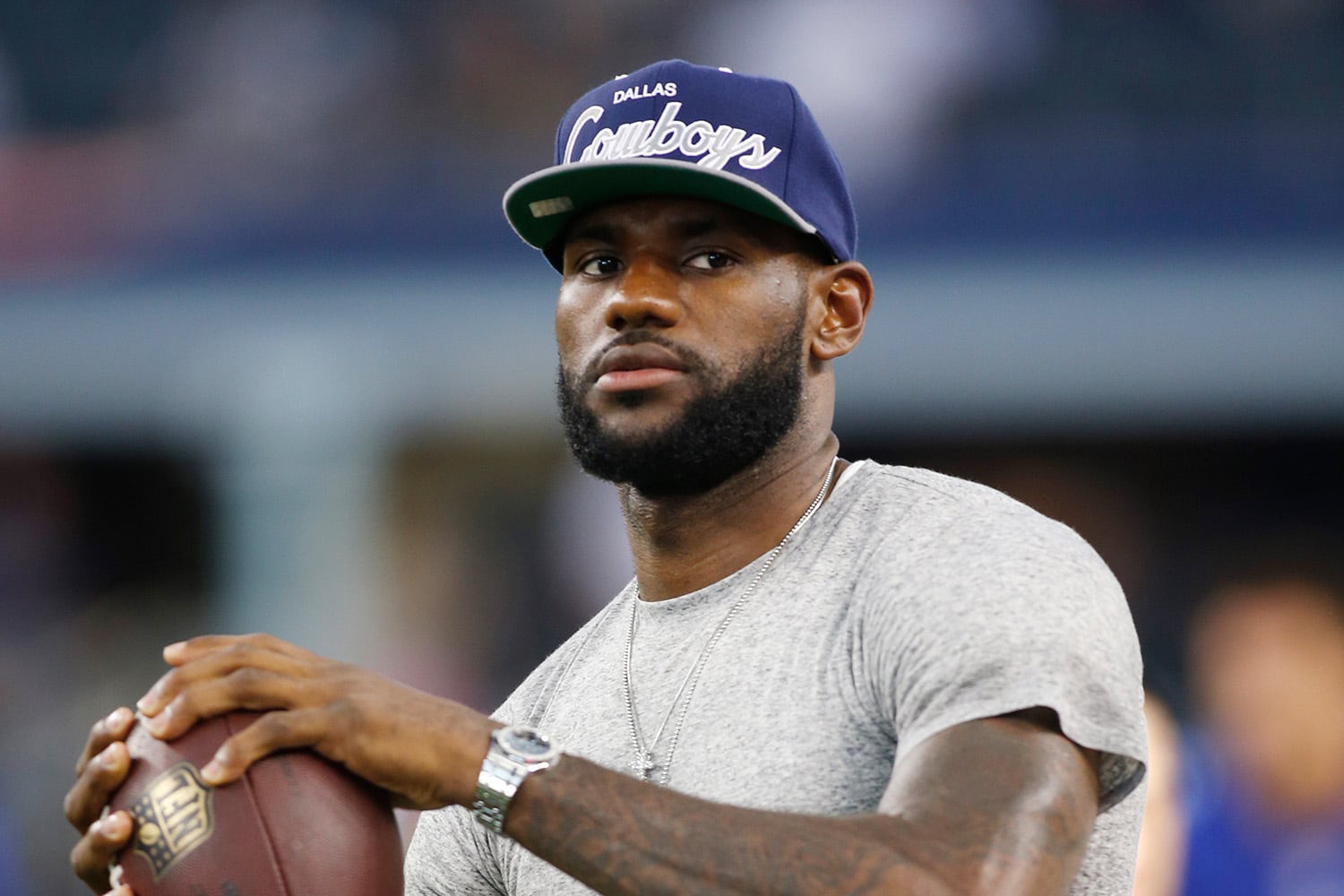LeBron James throws football while wearing Dallas Cowboys hat