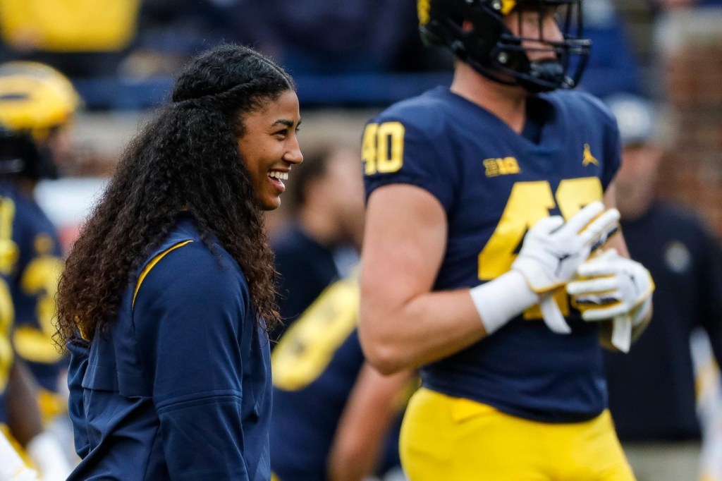 Michigans first female coach Milan “Mimi” Bolden-Morris laughs with players on field