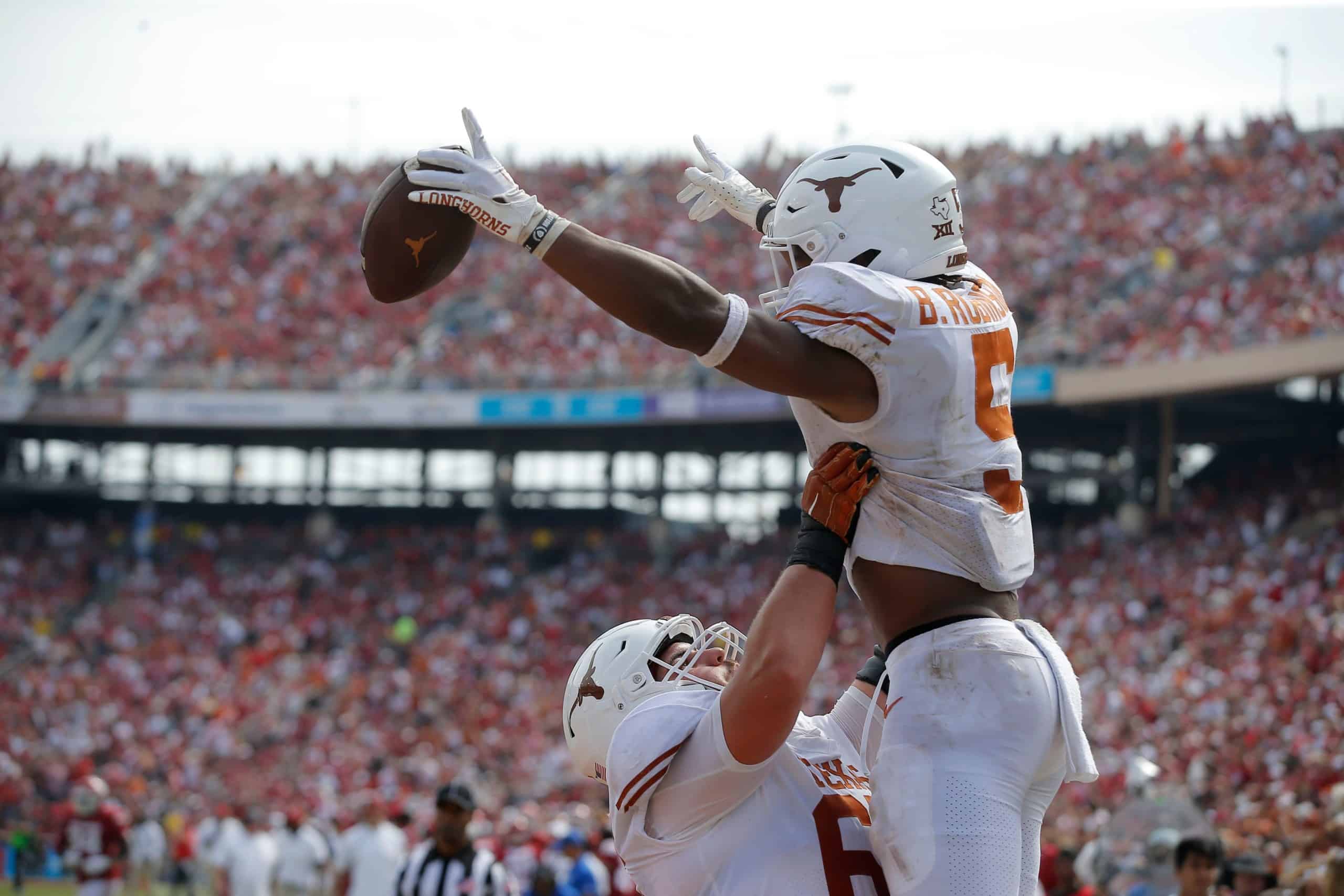 Texas Longhorns offensive lineman lifts up star running back Bijan Robinson after scoring a touchdown
