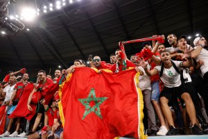 Moroccan fans hold up national flag and scarfs while supporting their team