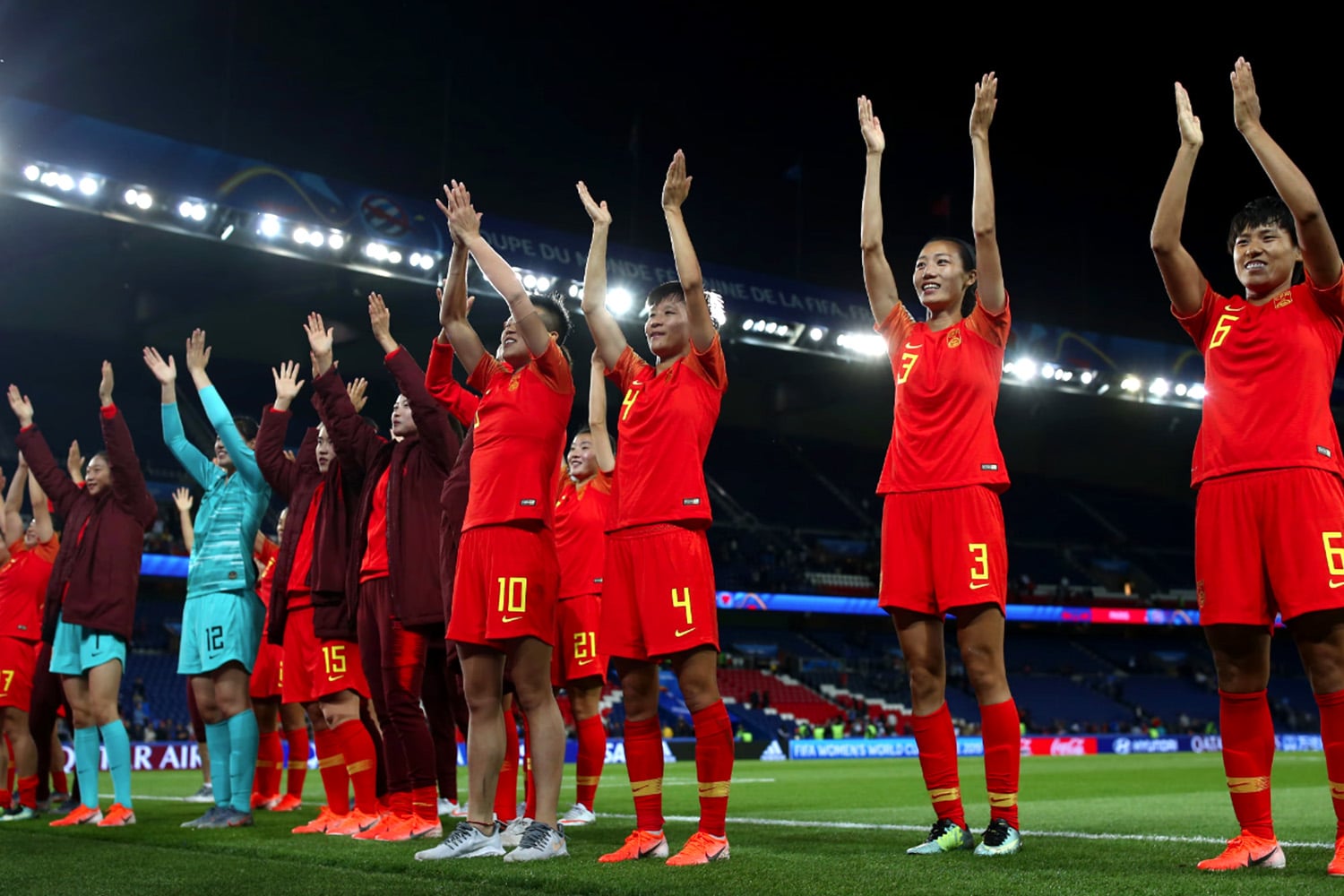 The China Women's National Soccer team clap for fans after a match.
