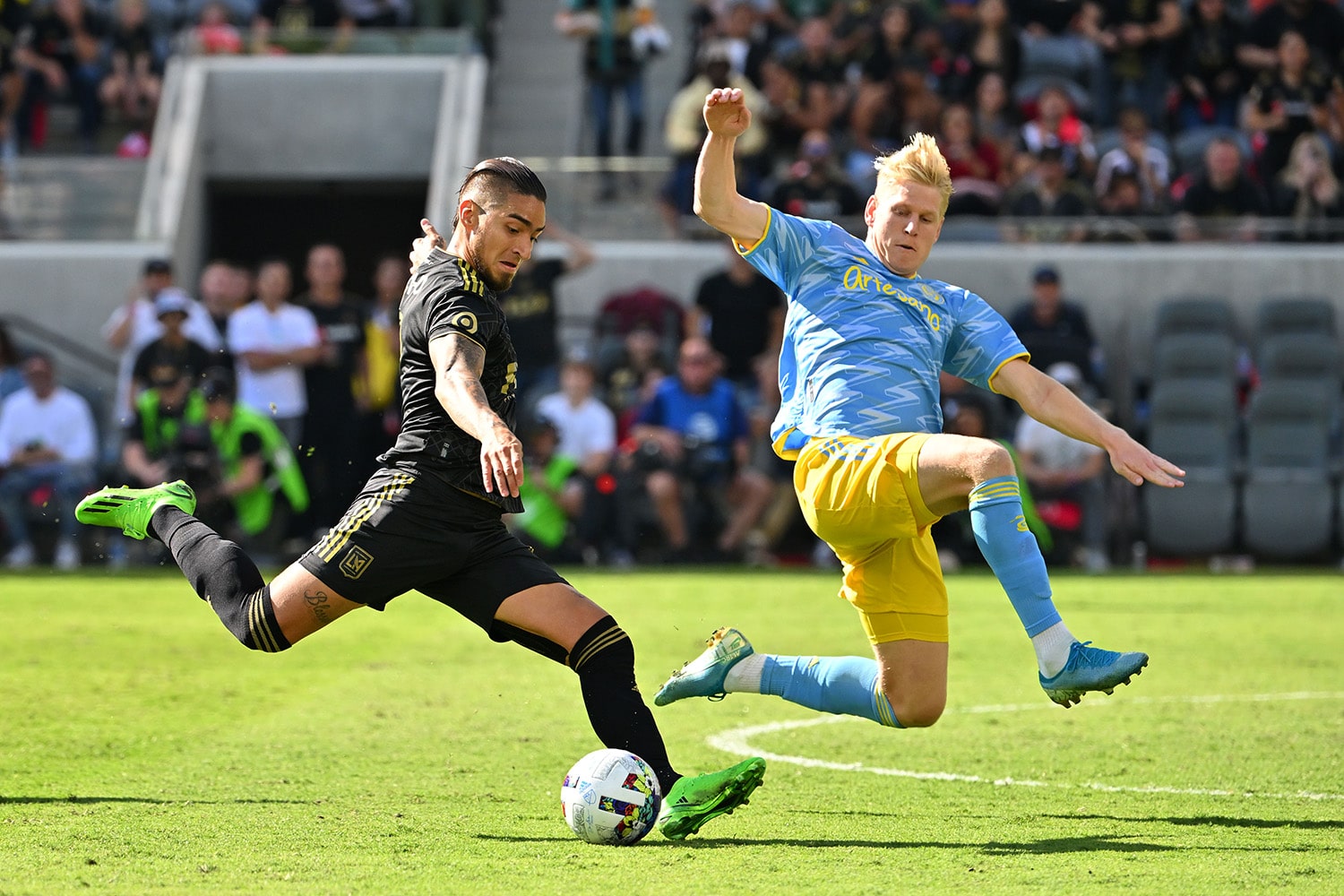 A player for the LAFC goes to strike the ball against a player for the Philadelphia Union during the 2022 MLS Cup Championship game.