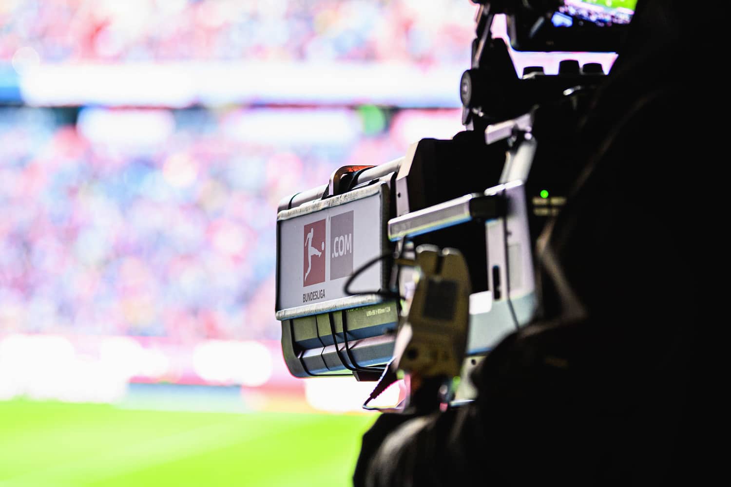 A Bundesliga broadcast camera is aimed towards the field.