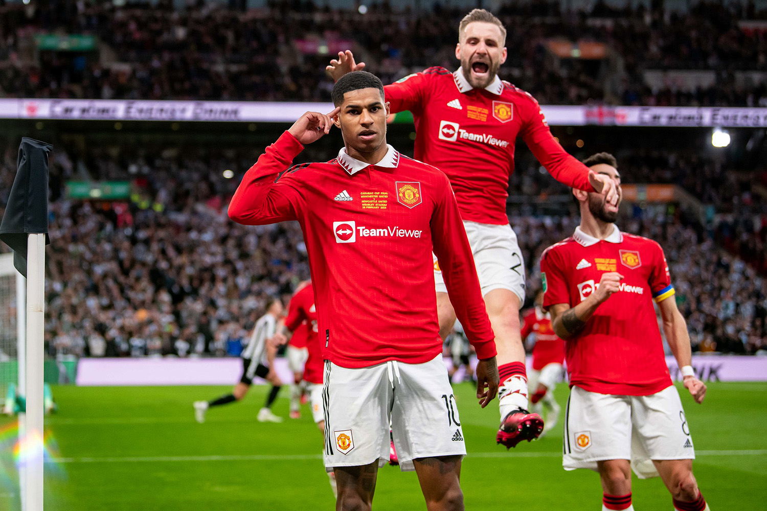 Manchester United forward Marcus Rashford celebrates with teammates after scoring.