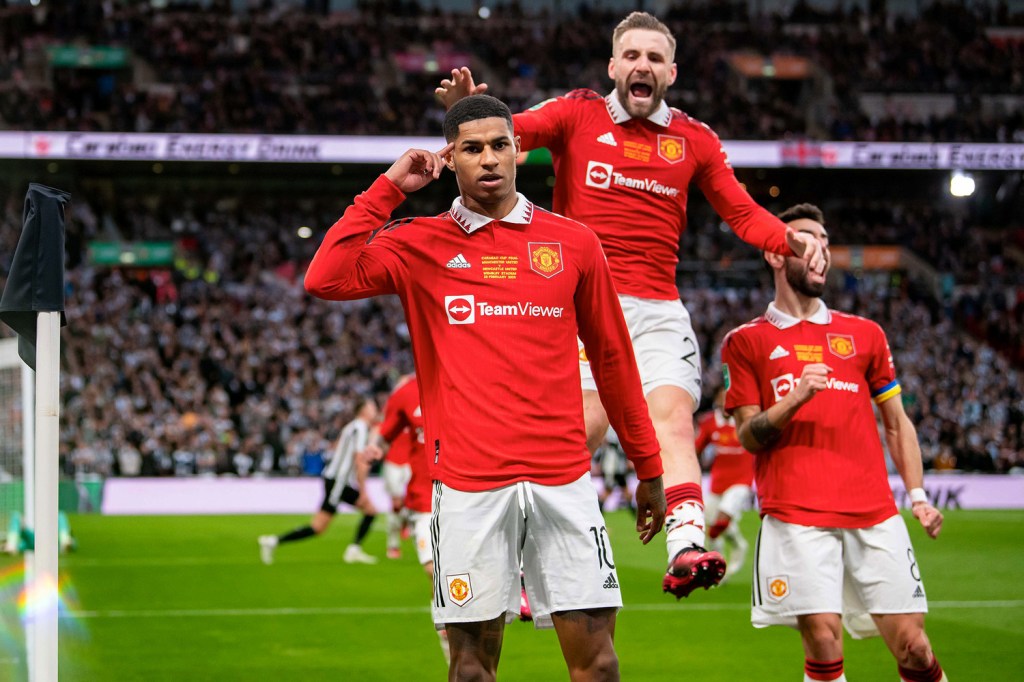 Manchester United forward Marcus Rashford celebrates with teammates after scoring.