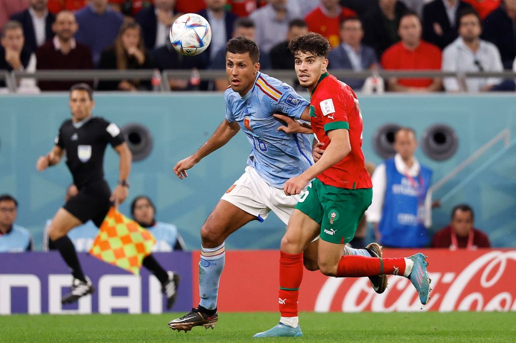 A Spain and Morocco player fight for the ball during their round of sixteen match at the 2022 FIFA World Cup.