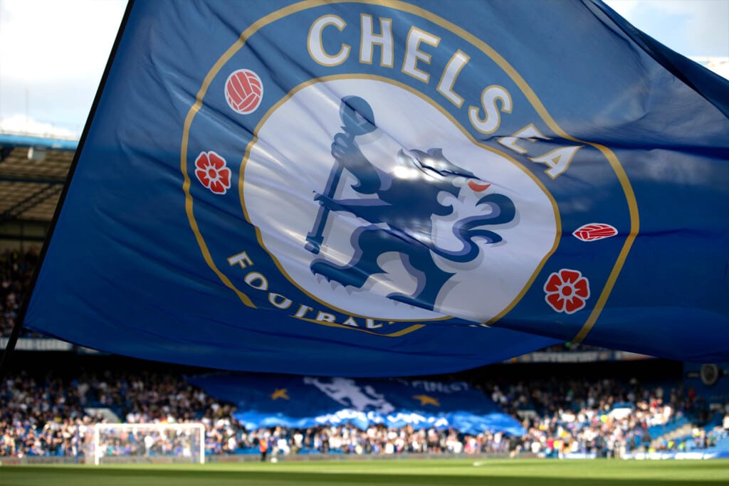 A Chelsea FC banner is waved over the field at Stamford Bridge stadium.
