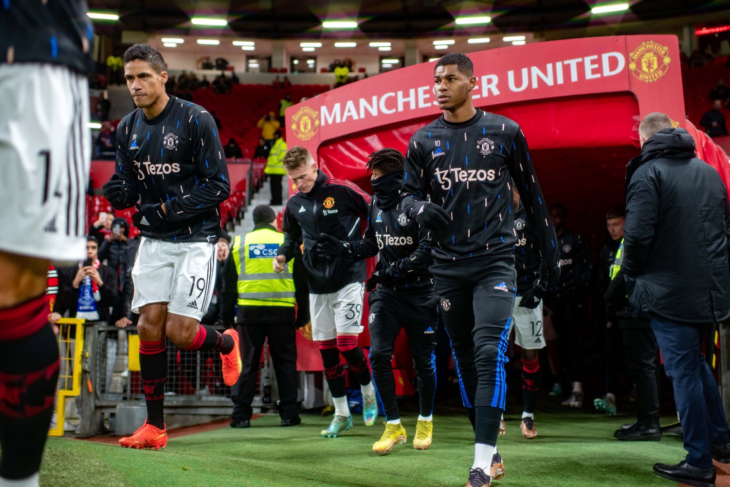Manchester United players enter the pitch from the tunnel before a match.