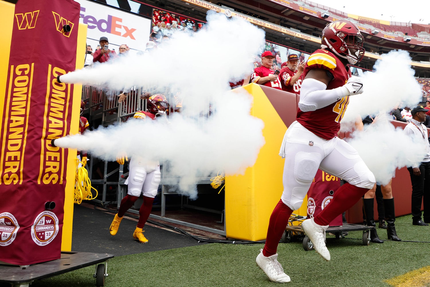 Washington Commanders players run onto the field prior to the game at FedexField