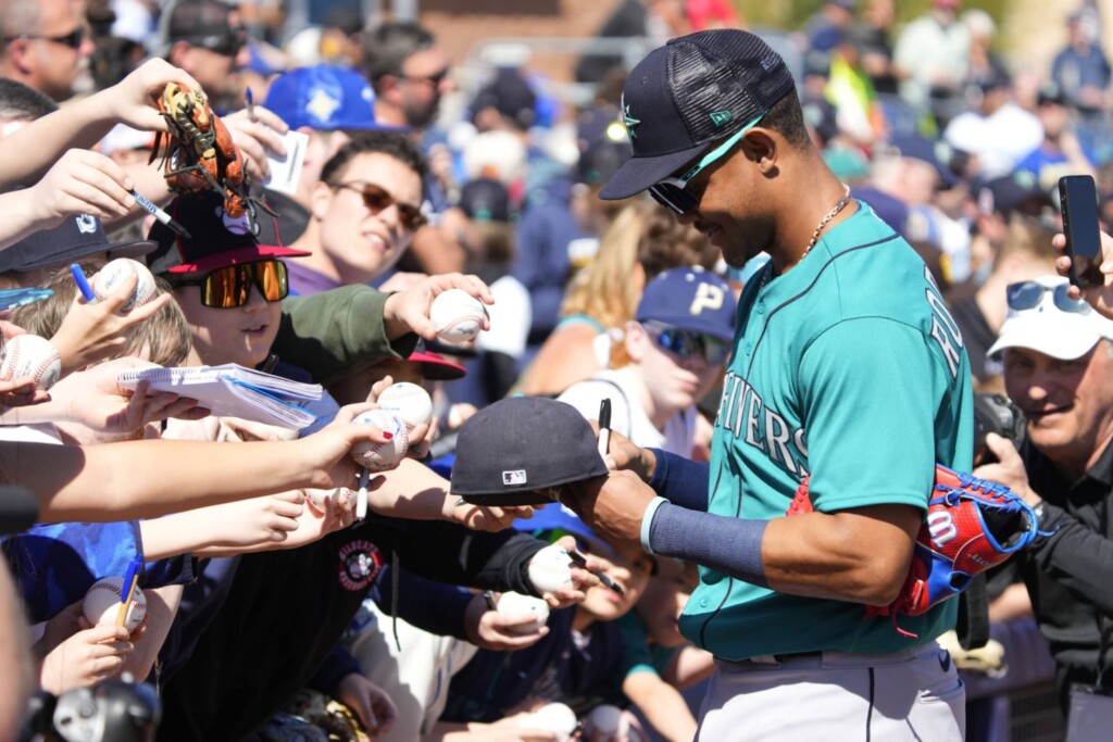 Feb 24, 2023; Peoria, Arizona, USA; Seattle Mariners center fielder Julio Rodriguez (44) signs autographs before a spring training game against the San Diego Padres at Peoria Sports Complex.