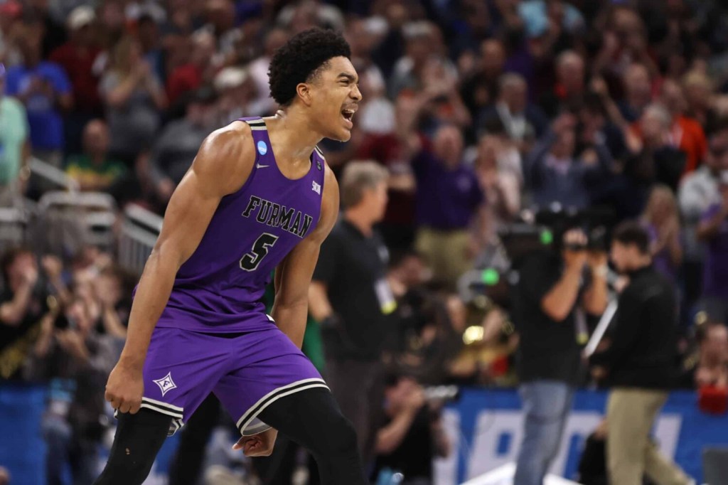 Mar 16, 2023; Orlando, FL, USA; Furman Paladins guard Marcus Foster (5) celebrates after defeating the Virginia Cavaliers at Amway Center.