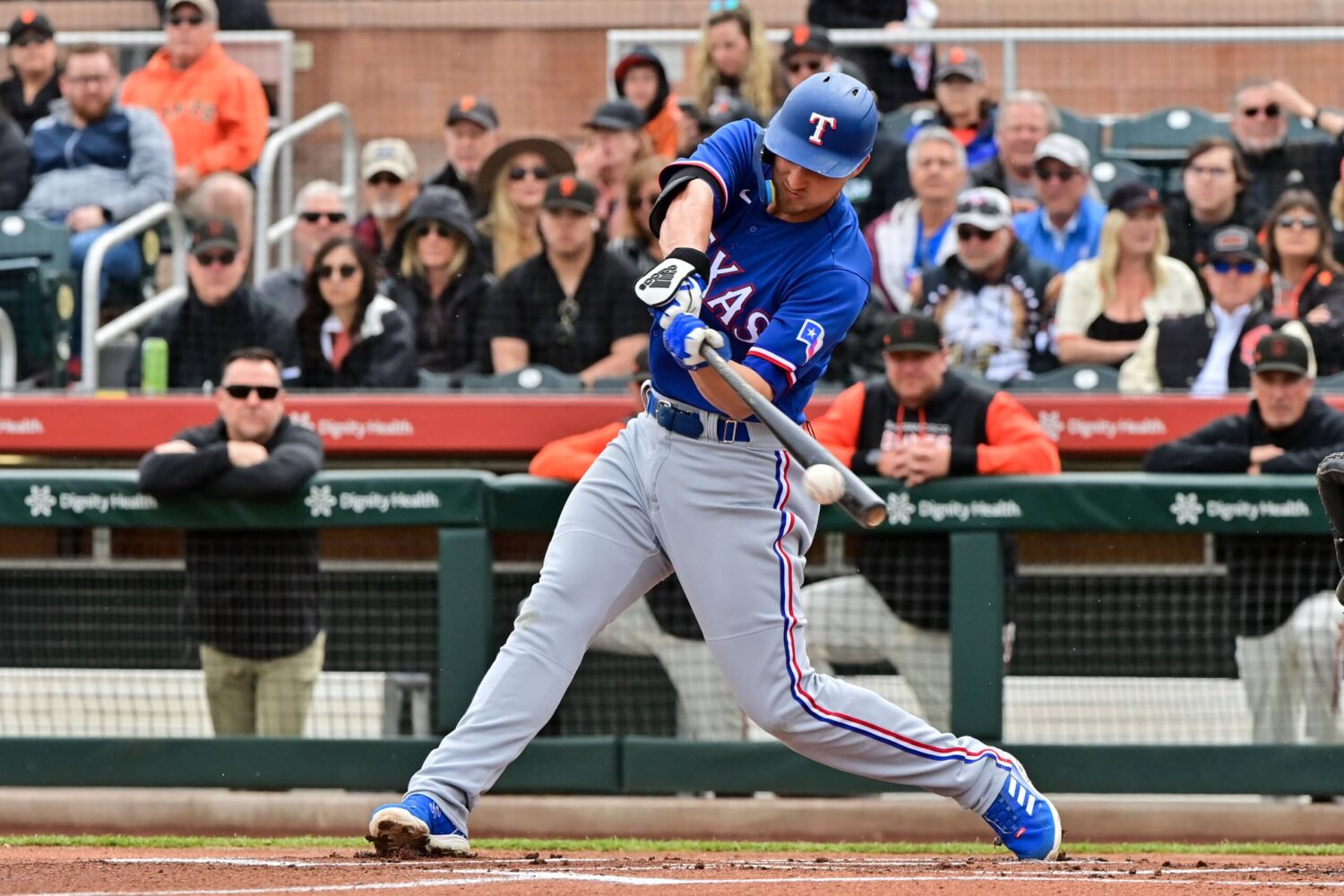 Mar 22, 2023; Scottsdale, Arizona, USA; Texas Rangers shortstop Corey Seager (5) singles in the first inning against the San Francisco Giants during a Spring Training game at Scottsdale Stadium.