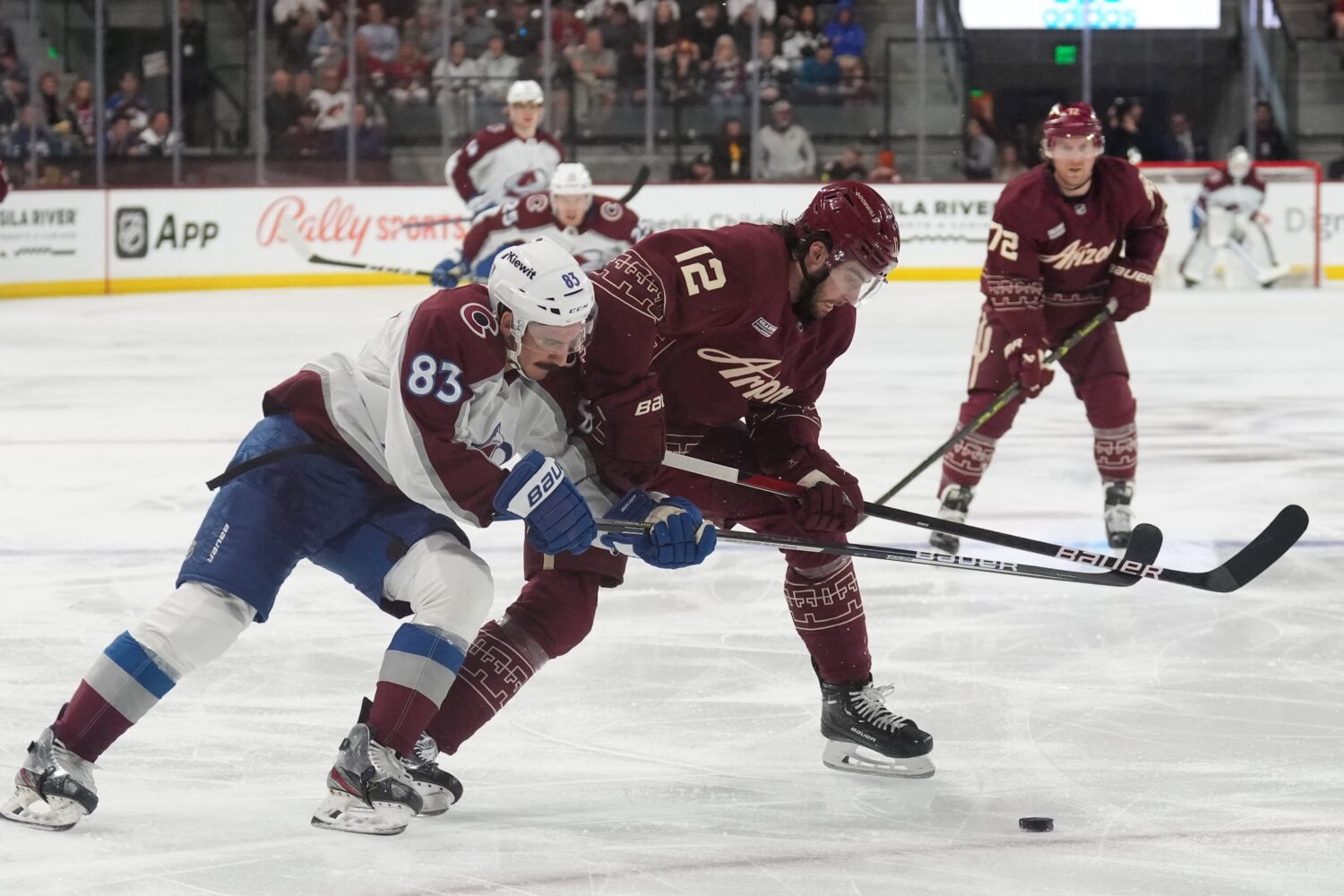 Colorado Avalanche left wing Matt Nieto (83) and Arizona Coyotes defenseman Connor Mackey (12) battle for the puck during the third period at Mullett Arena.