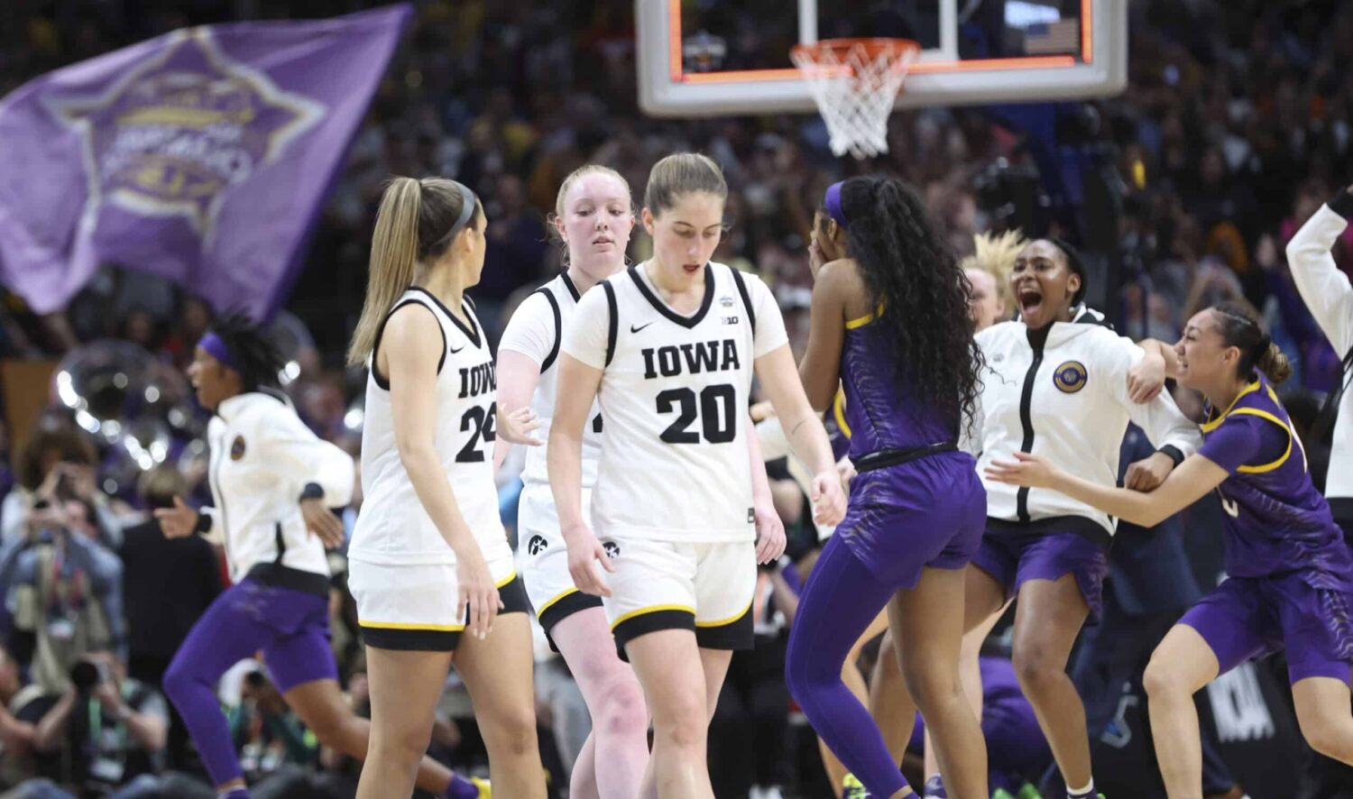Iowa Hawkeyes players leave the court as LSU Lady Tigers players celebrate behind them after the game during the final round of the Women's Final Four NCAA tournament at the American Airlines Center.
