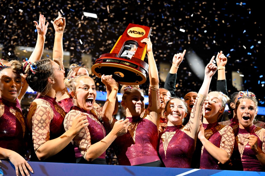 Apr 15, 2023; Fort Worth, TX, USA; The University of Oklahoma Sooners celebrate with the trophy as confetti falls after the Sooners win the national championship at the NCAA Women's National Gymnastics Tournament Championship at Dickies Arena.