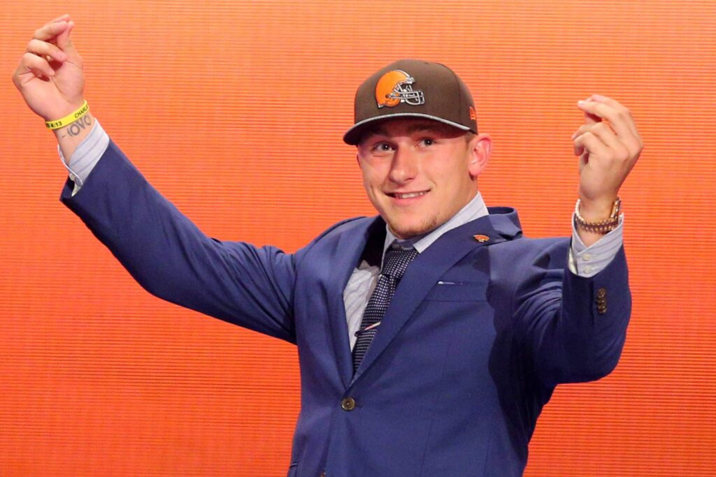 Johnny Manziel makes his signature money gesture as he walks across the stage at the 2014 NFL Draft.