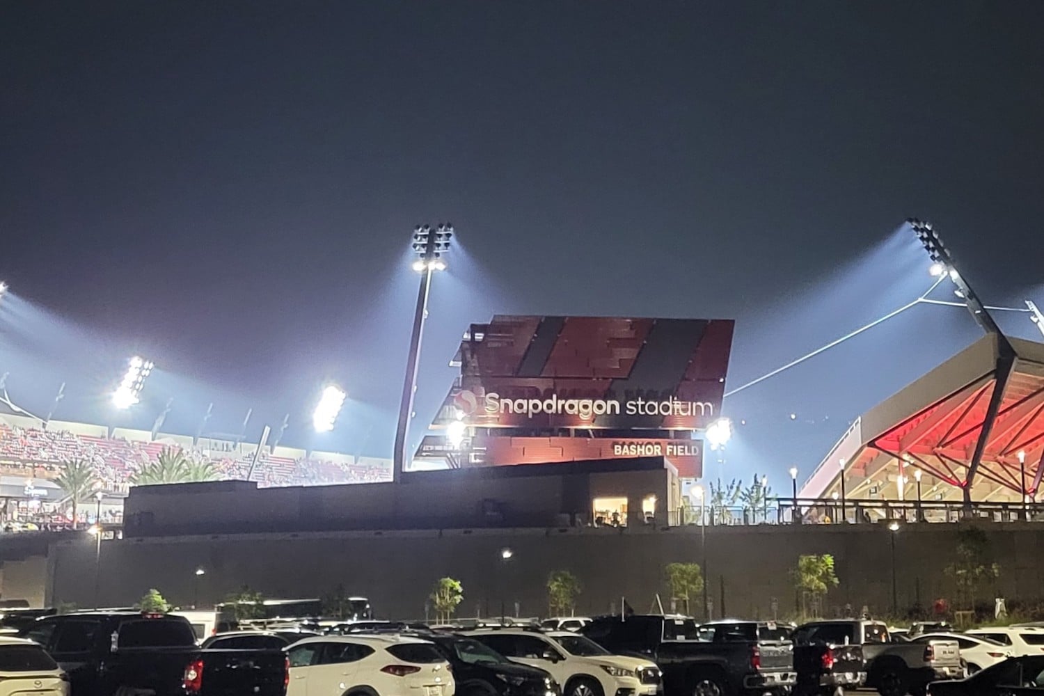 An exterior view of Snapdragon Stadium at night.