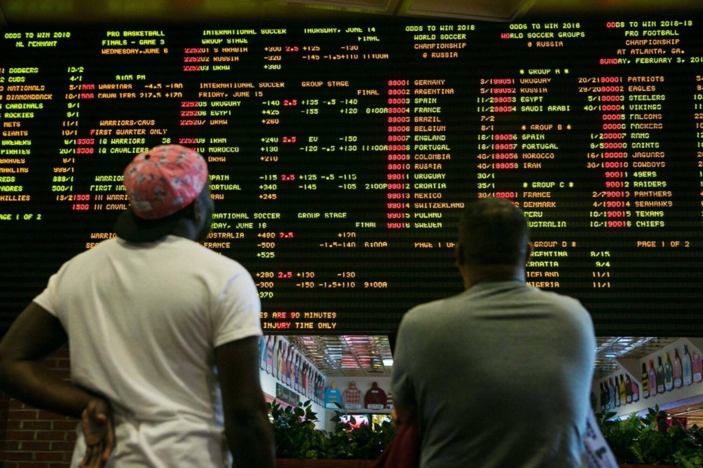 Two prospective sports bettors look at a betting board at a casino in Delaware.