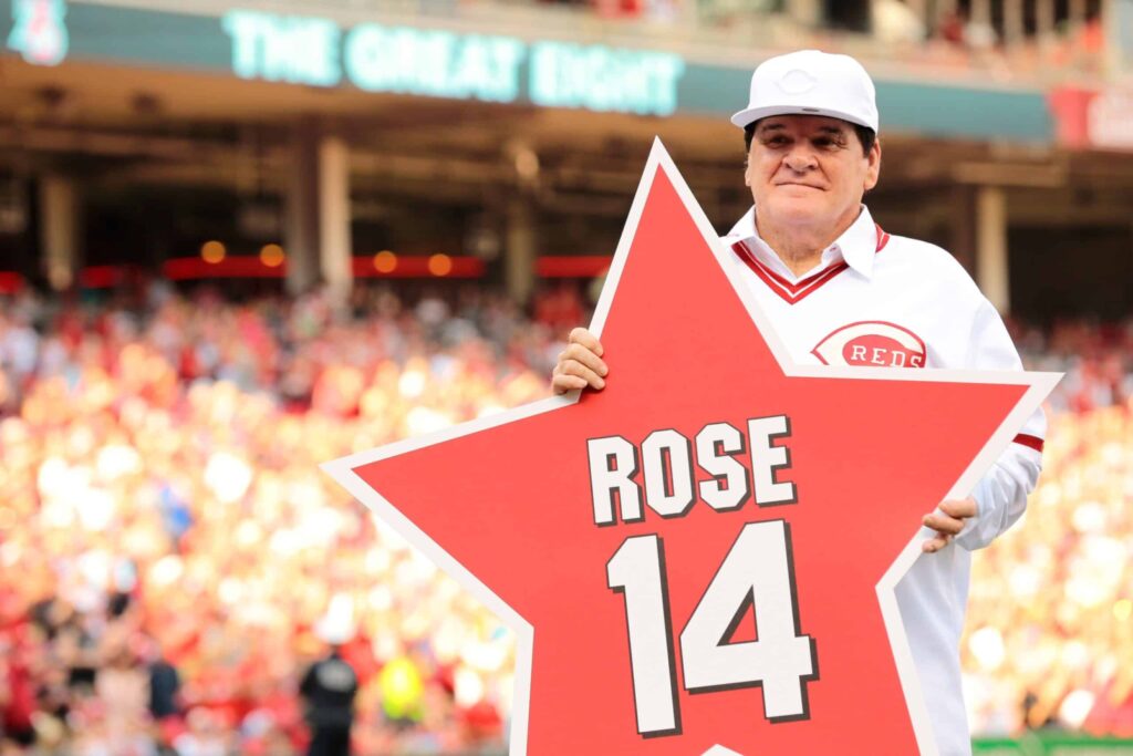 Former Cincinnati Reds player and manager Pete Rose poses with a star with his name and number on it.