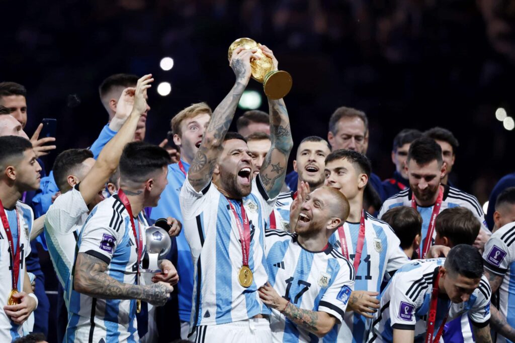 Argentina defender Nicolas Otamendi holds up the World Cup trophy at the 2022 World Cup in Qatar.