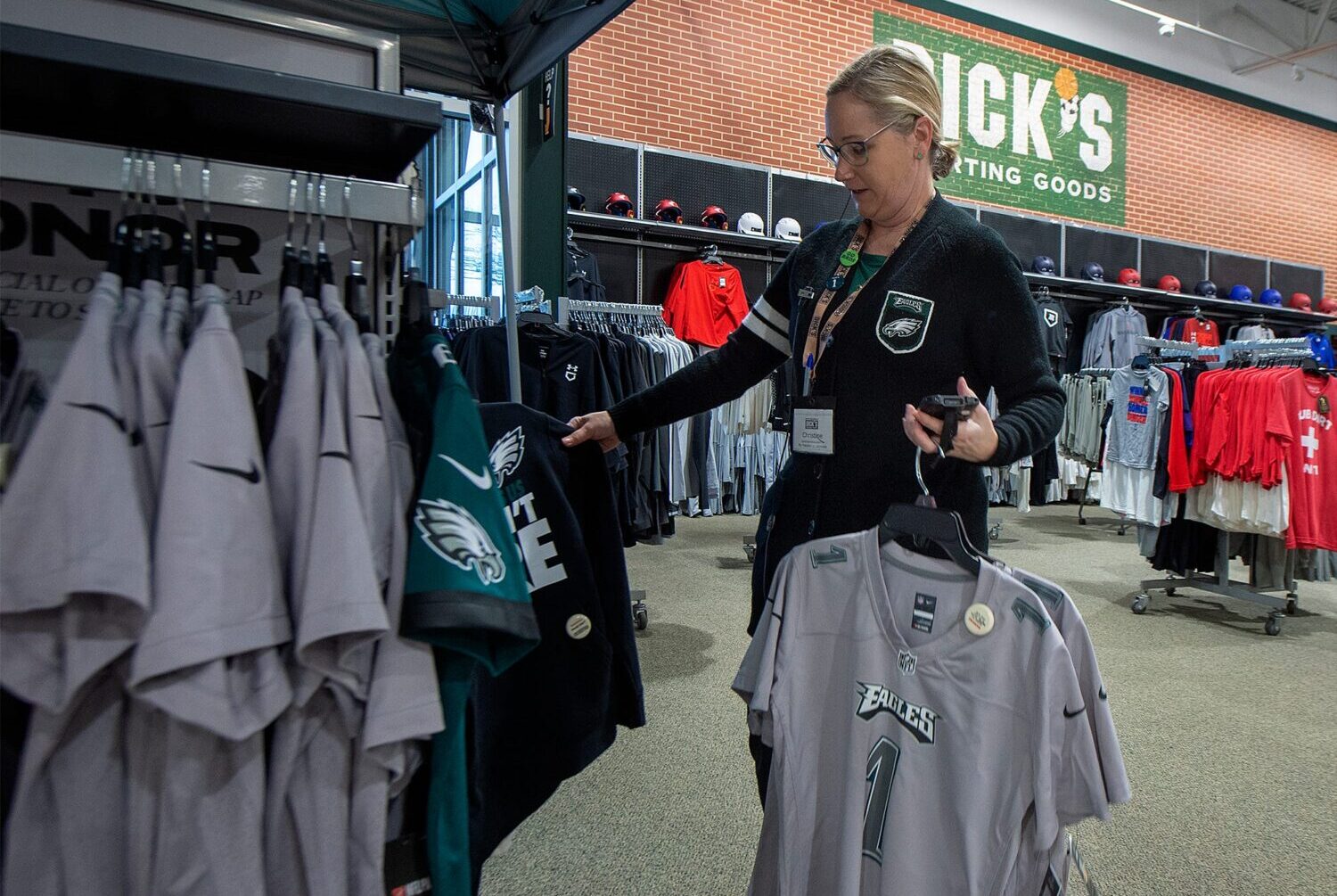 At Dick's Sporting Goods in Fairless Hills, Store Administrative Assistant Christine Vandfermay, of Philadelphia, restocks some Philadelphia Eagles items.