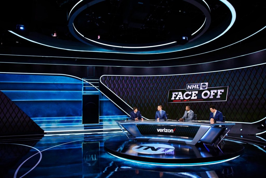 A wide angle view of the "NHL on TNT" studio desk with Wayne Gretzky, Liam McHugh, Anson Carter, and Paul Bissonnette.