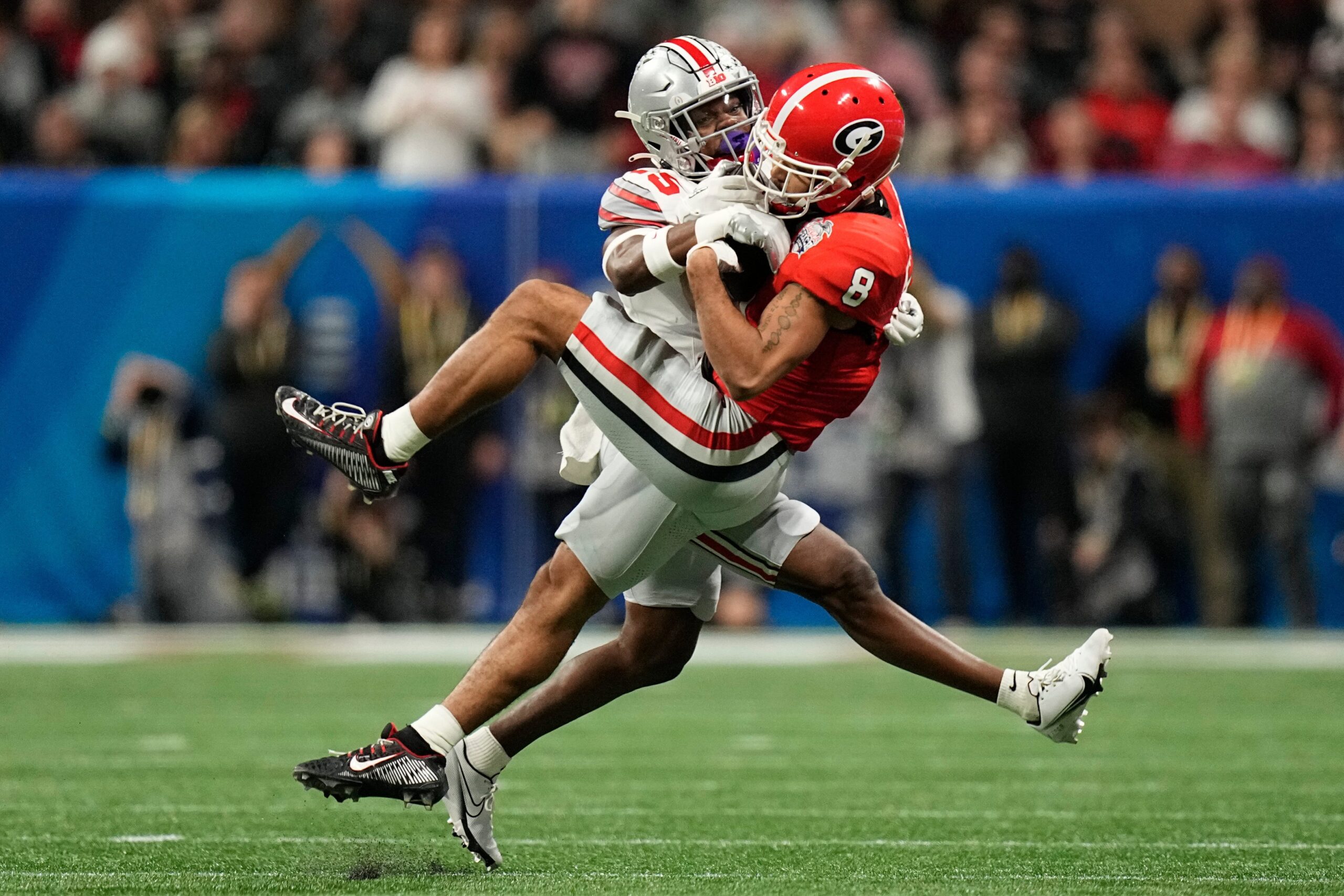 Georgia Bulldogs wide receiver Dominick Blaylock (8) catches a pass while being defended by Ohio State Buckeyes safety Jaylen Johnson (25) during the first half of the Peach Bowl.