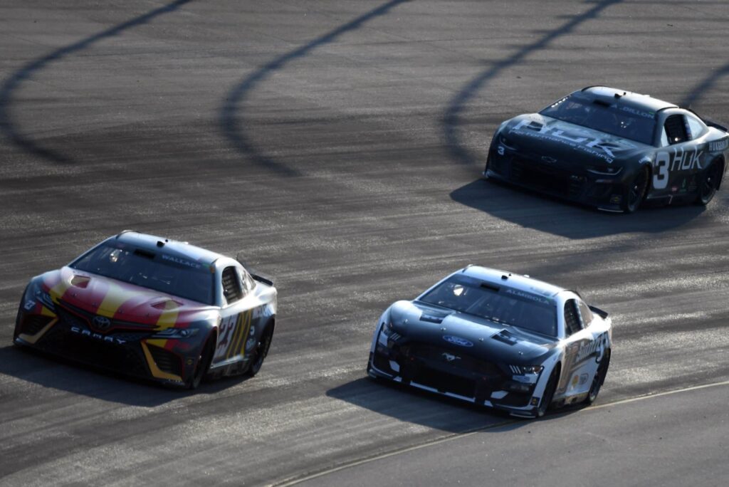 NASCAR Cup Series driver Bubba Wallace leads Aric Almirola and Austin Dillon into turn two during the Ally 400 at Nashville Superspeedway.